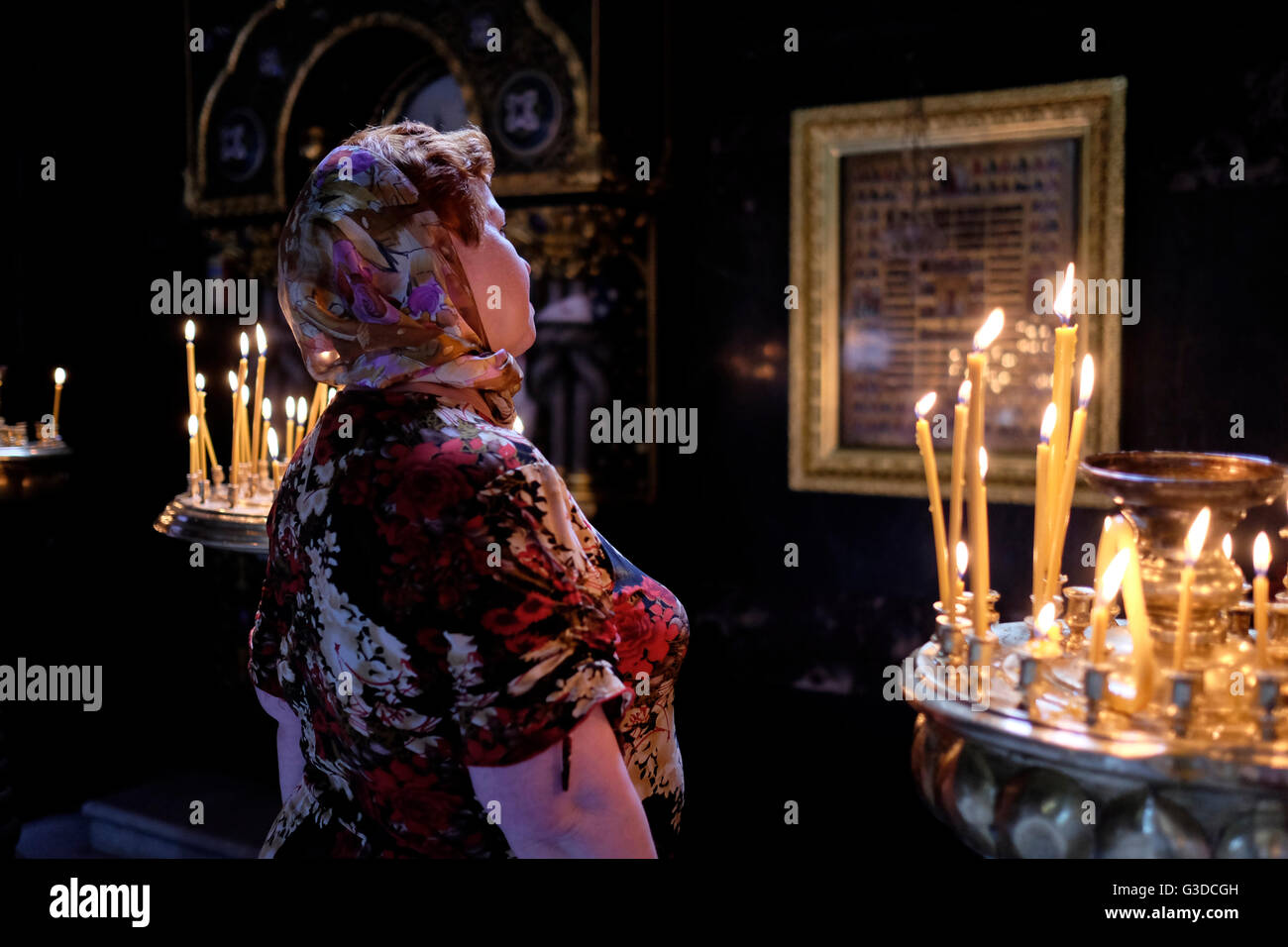 Una donna Ucraina prega di fronte all'icona religiosa dopo un servizio di preghiera della Chiesa ortodossa Ucraina del patriarcato di Kiev nella cattedrale di San Volodimir, nel centro di Kiev, Ucraina Foto Stock