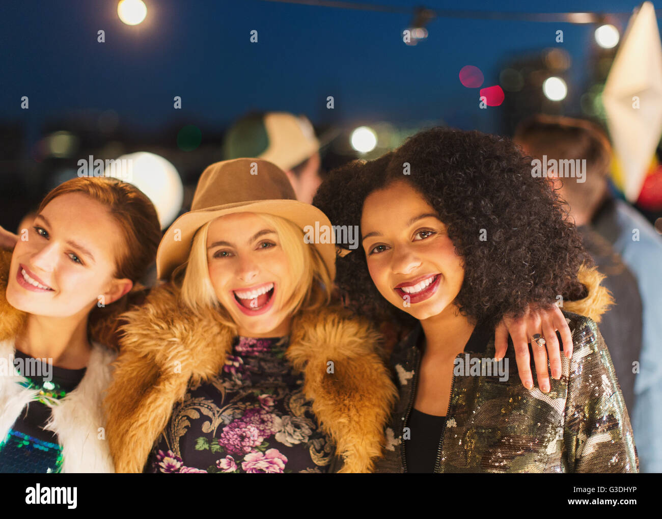 Ritratto sorridente giovani donne godendo di partito sul tetto Foto Stock