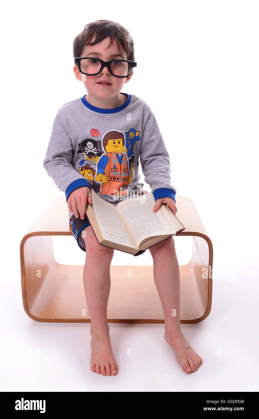 Giovane ragazzo il relax e la lettura di un libro con occhiali, la dislessia Foto Stock