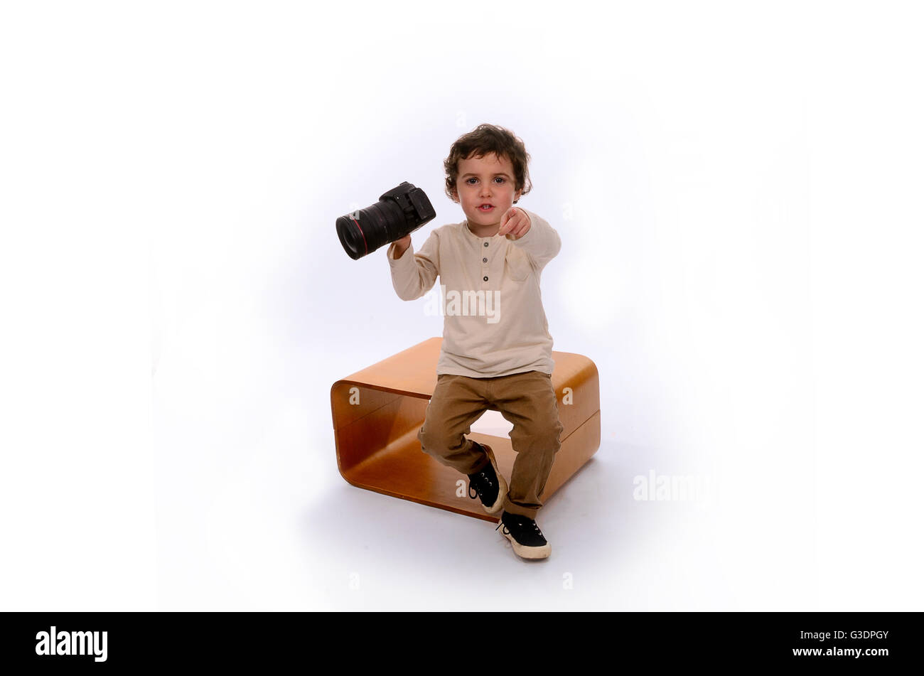 Ragazzo giocando con fotocamera digitale in studio Foto Stock