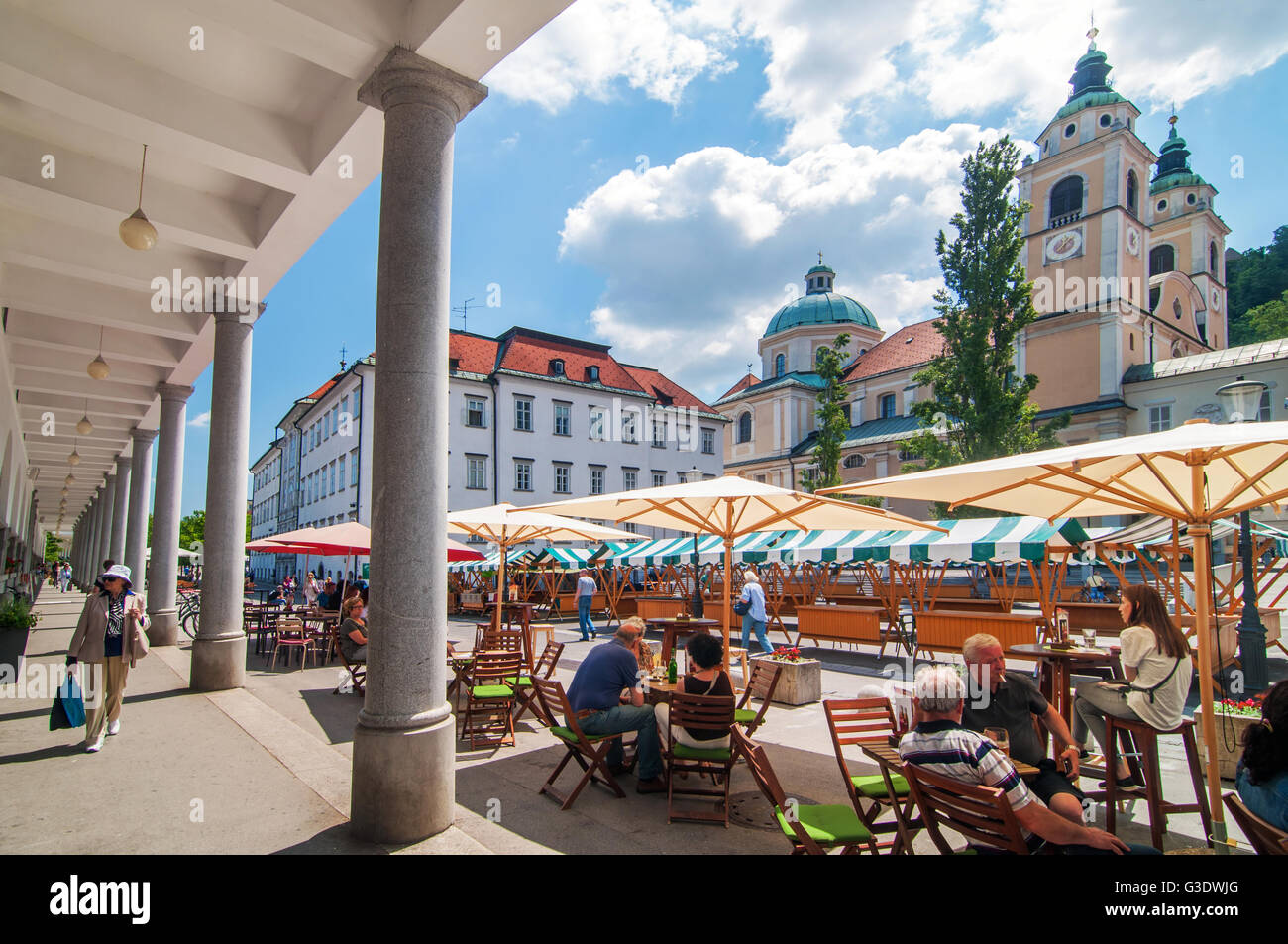 Ljubljana, Slovenia - 7 giugno 2016 persone a passeggiare e a fare shopping a Lubiana il mercato centrale, la chiesa di San Nicola in background Foto Stock