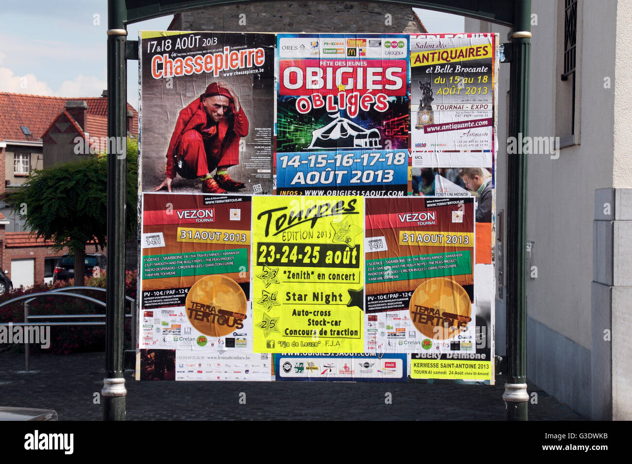 Intrattenimento assortiti fly poster su un pubblico information board di Tournai, Hainaut, Belgio. Foto Stock