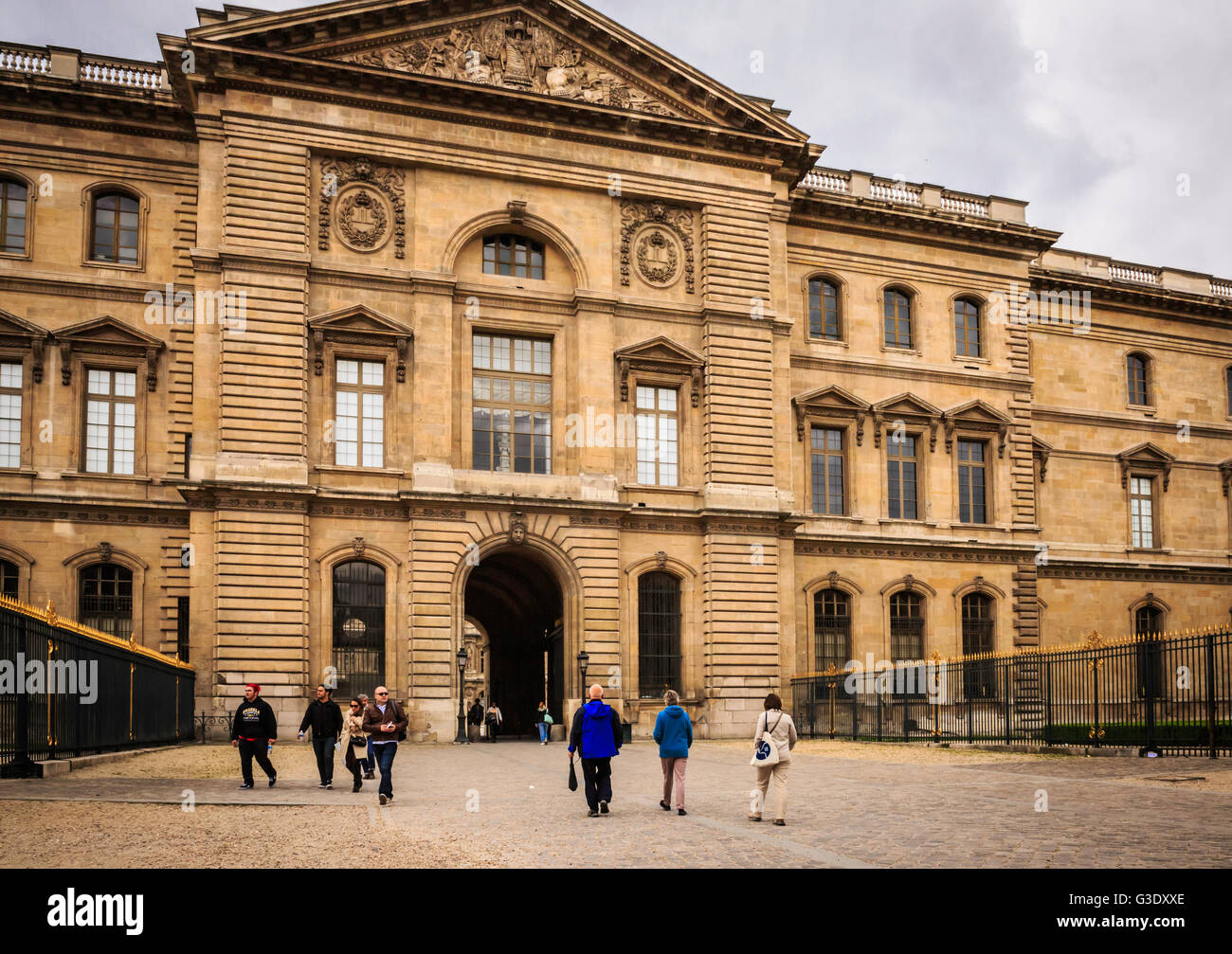 I turisti passeggiano al di fuori del Louvre, una volta a palazzo reale e ora un museo a Parigi e una grande attrazione turistica. Foto Stock