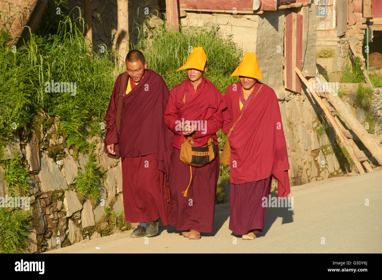 Un monaco e due monache nelle strade di Larung Gar Foto Stock