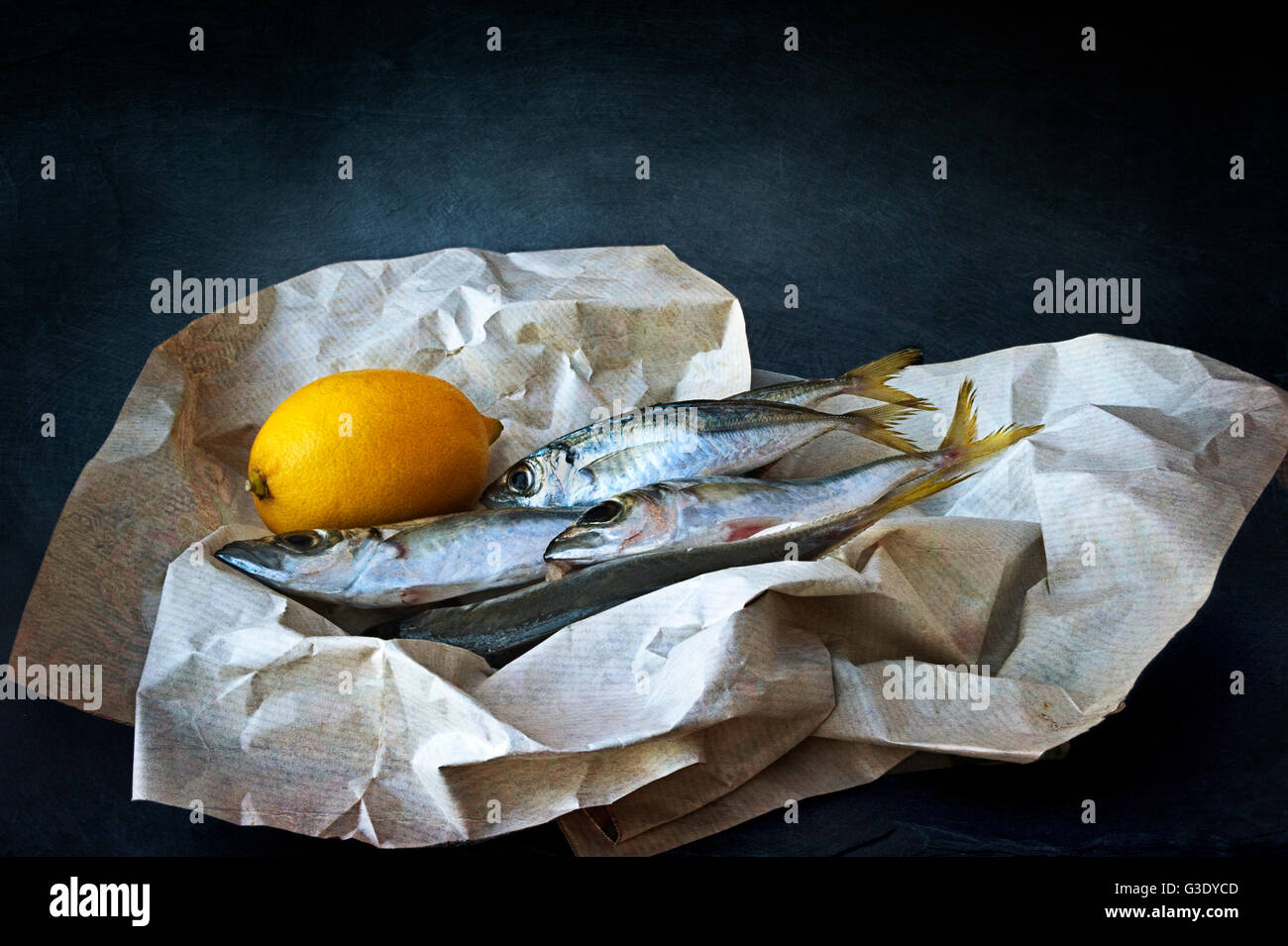 Sarde fresche con il limone avvolte in carta Foto Stock