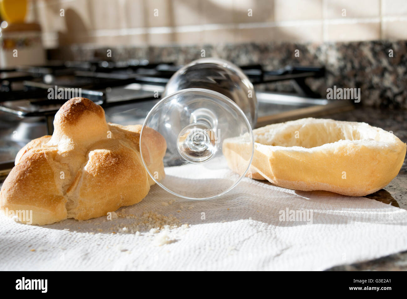 Pane tagliato a metà con un bicchiere di birra su una stufa-top Foto Stock