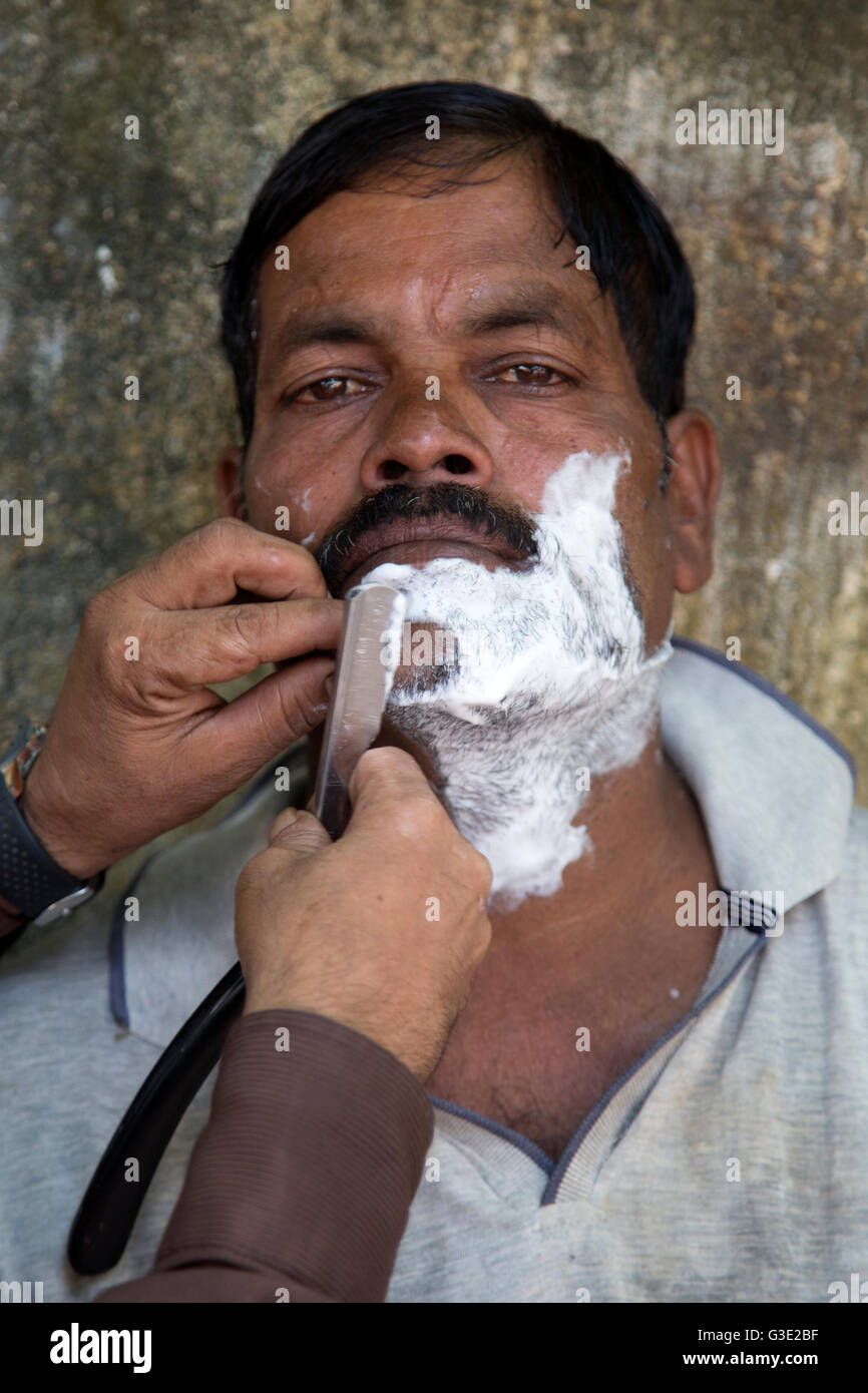 MUMBAI, India - 10 ottobre 2015: l'uomo non identificato da radere al barbiere di Mumbai, in India. Si tratta di una tradizione locale. Foto Stock