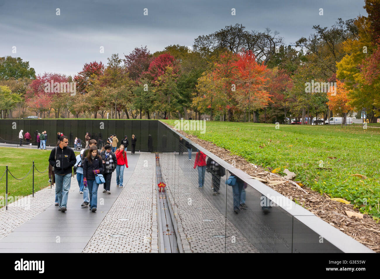I visitatori del Vietnam Veterans Memorial, dove i nomi dei morti della guerra del Vietnam sono incisi sulla parete di granito nero, Washington DC, USA Foto Stock