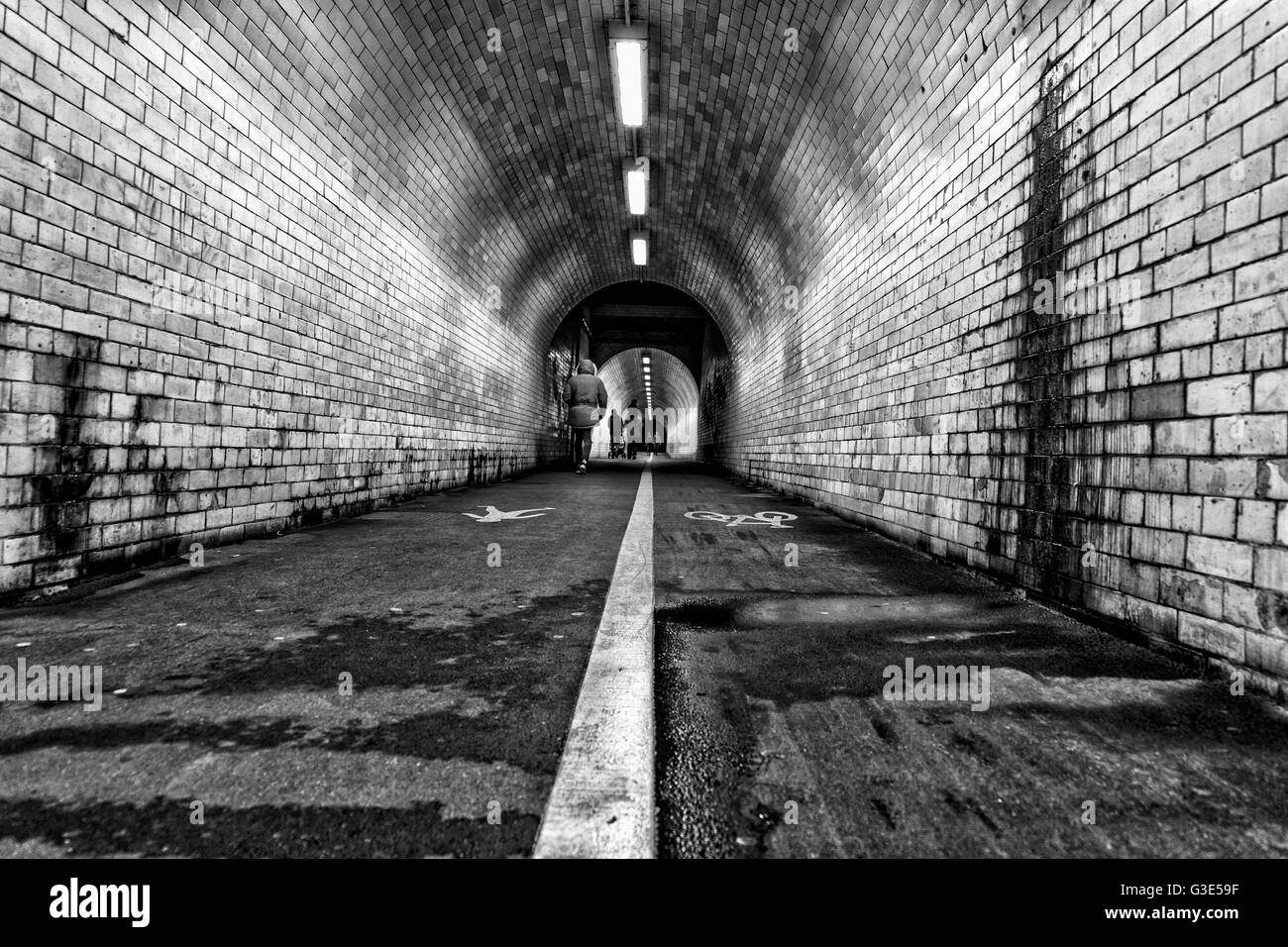 La linea bianca al centro di una sporca, usurate e pedonale ciclismo tunnel; York, nello Yorkshire, Inghilterra Foto Stock