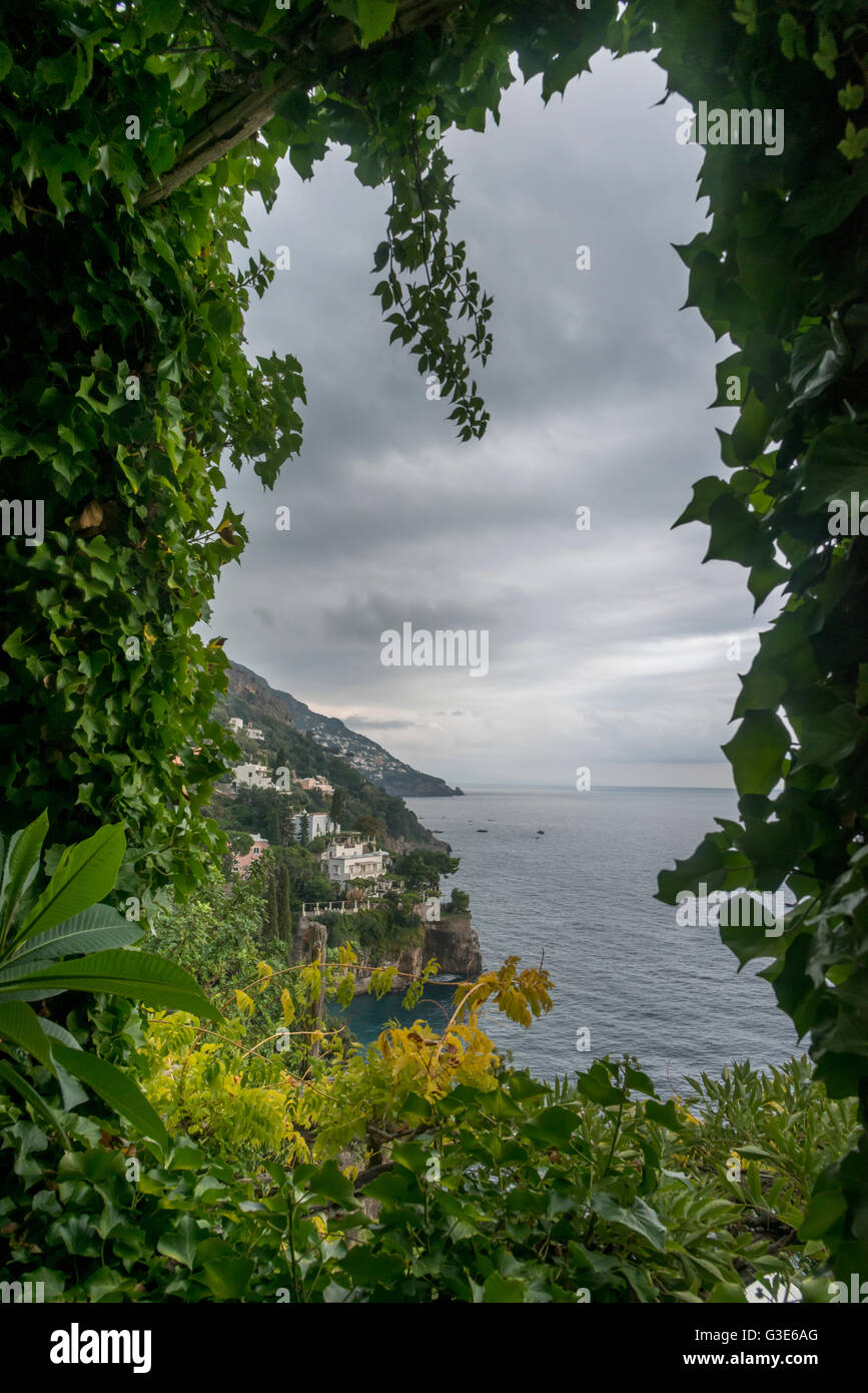 Vegetazione lussureggiante che incorniciano la vista della Costiera Amalfitana, Positano, Campania, Italia Foto Stock