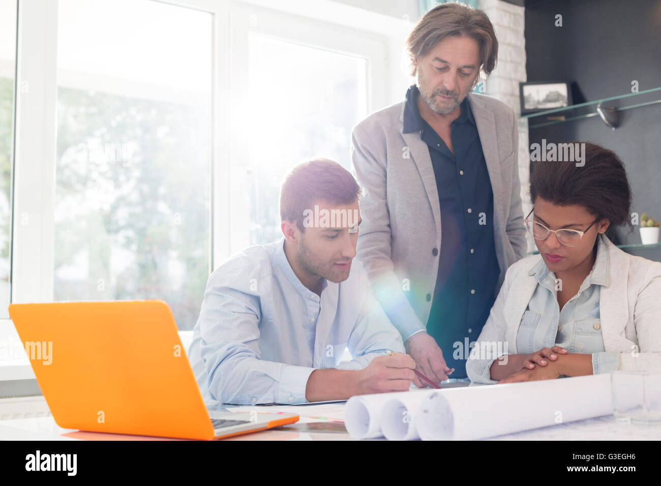 Architetti discutendo blueprint in office meeting Foto Stock