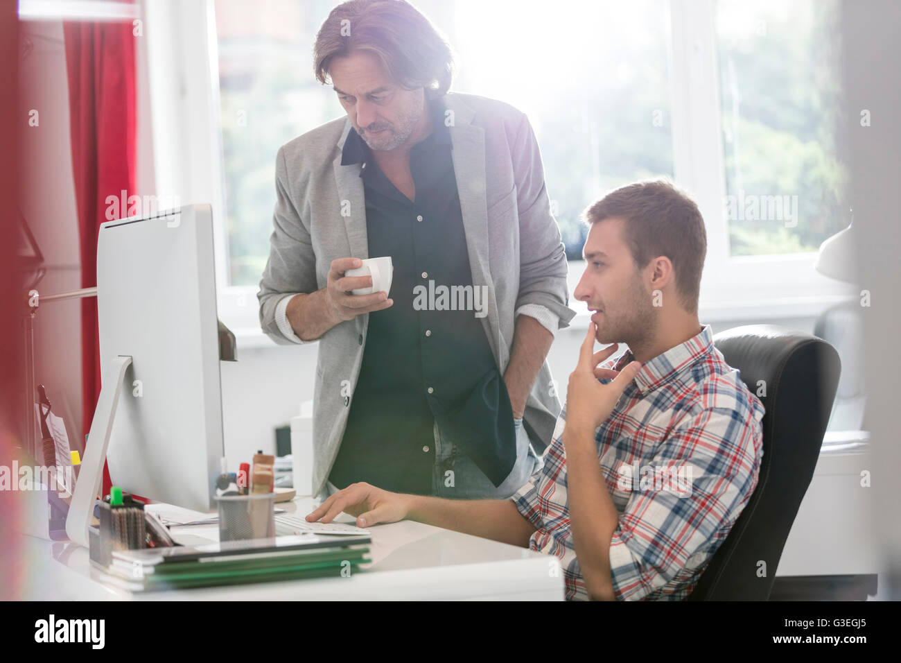 Imprenditori a bere caffè e lavorare al computer in ufficio Foto Stock