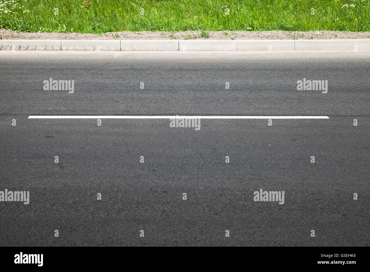 Autostrada vuota con una linea di demarcazione, su strada e di erba verde, abstract background di trasporto Foto Stock