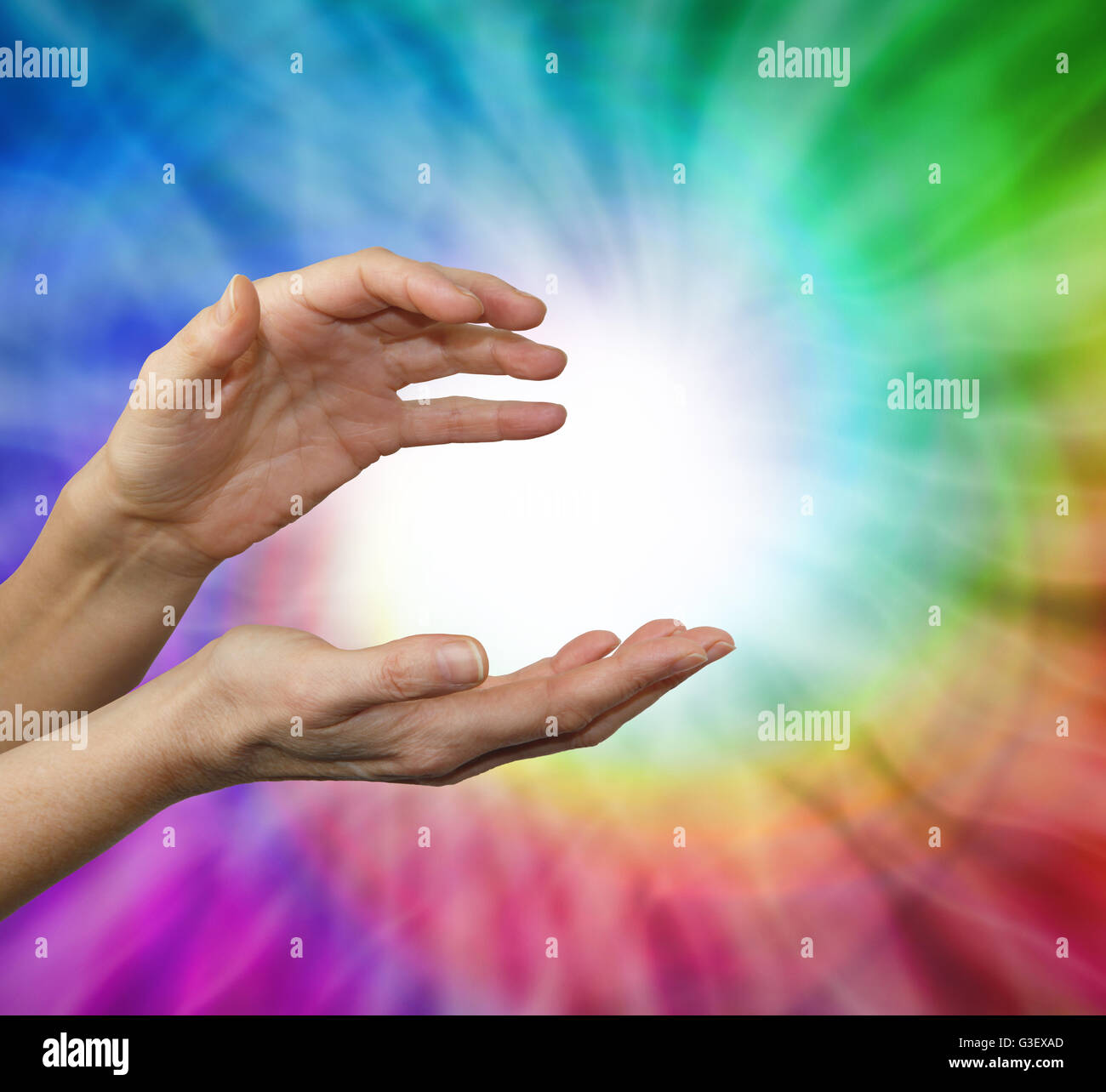 Mani femminili a tazza di energia in posizione di rilevamento con un arcobaleno vortex dietro e una sfera di energia bianca al centro Foto Stock