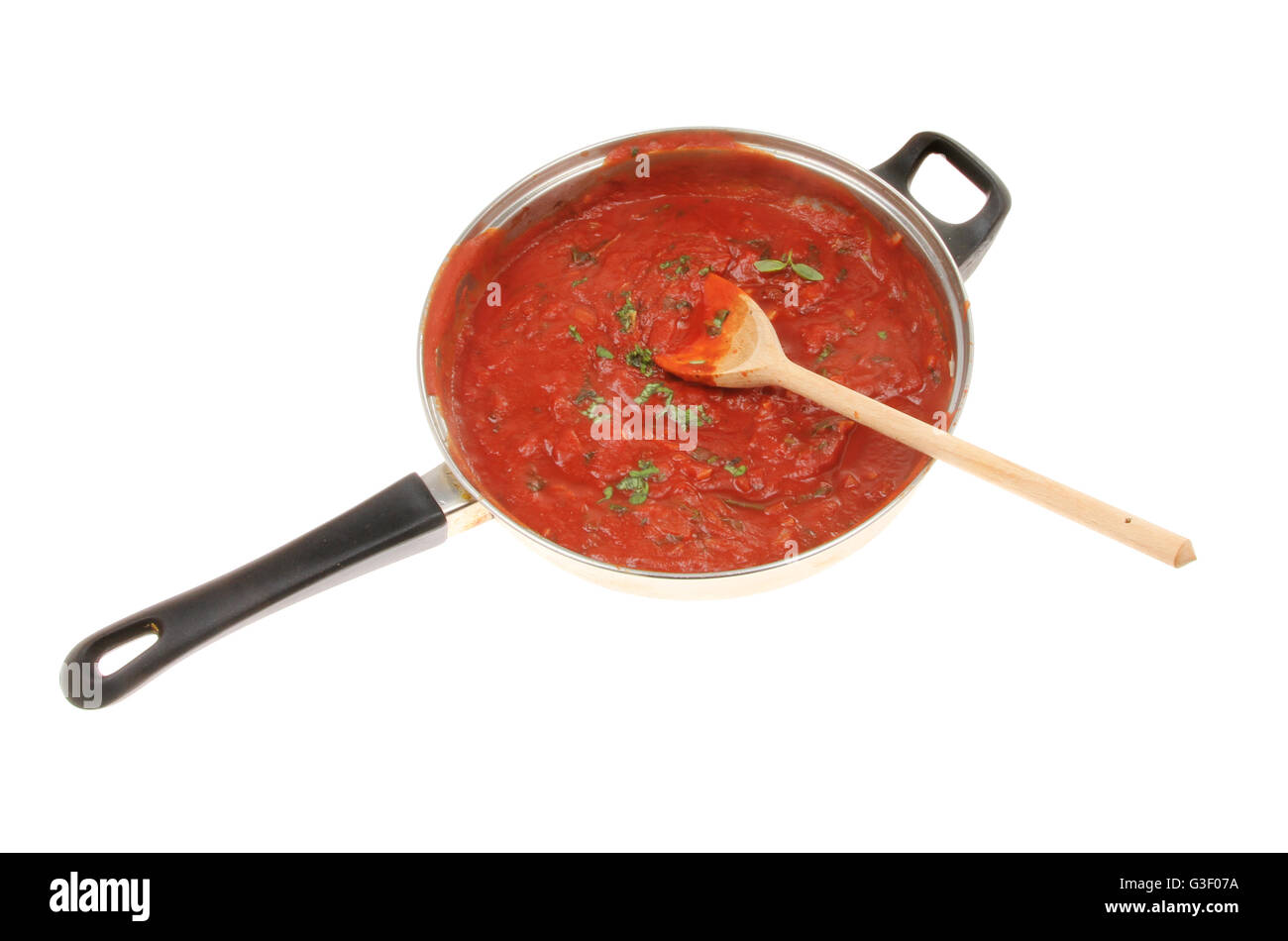Pomodoro e Basilico salsa in una padella con un cucchiaio di legno isolata contro bianco Foto Stock