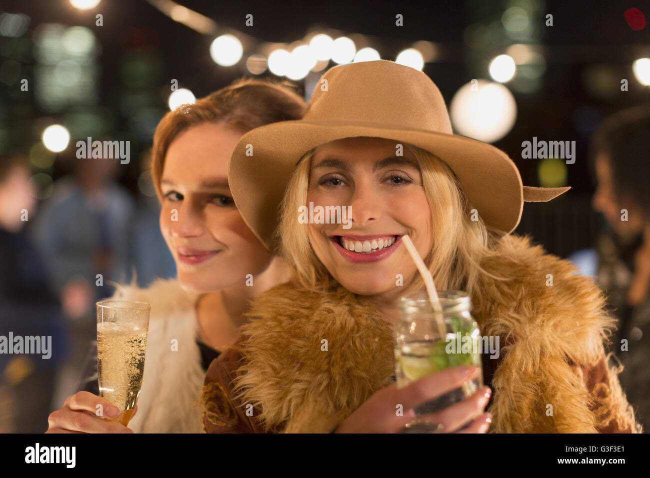Ritratto di sorridere le giovani donne a bere un cocktail a parte Foto Stock