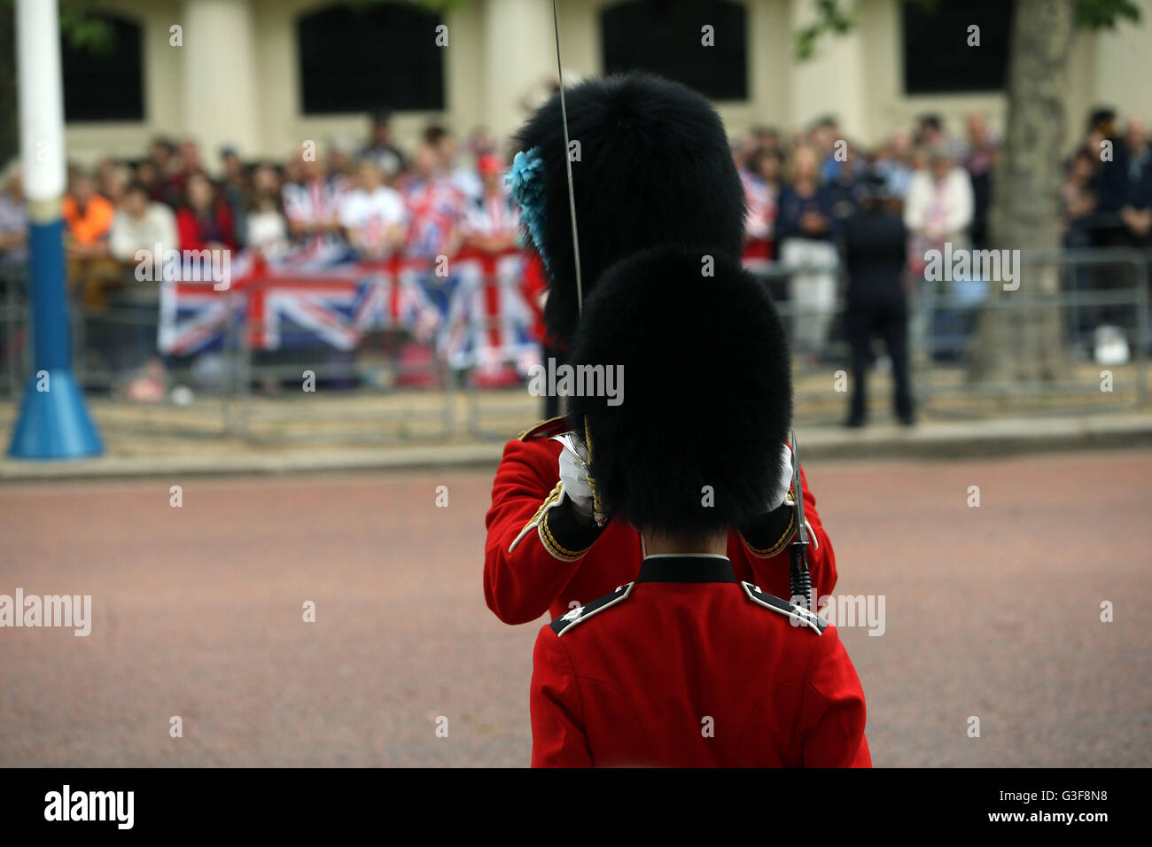 Un bearskin viene regolata prima che la royal cammino processionale verso il basso il Mall da Buckingham Palace e il centro di Londra per la sfilata delle Guardie a Cavallo per il Trooping la cerimonia di colore come la regina festeggia il suo compleanno ufficiale di oggi. Foto Stock