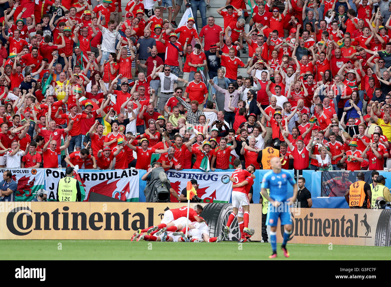 Il Galles Hal Robson-Kanu (oscurato) viene assaliti da compagni di squadra come egli celebra il loro punteggio secondo obiettivo del gioco durante UEFA EURO 2016, gruppo B corrispondono allo Stade de Bordeaux Bordeaux. Foto Stock