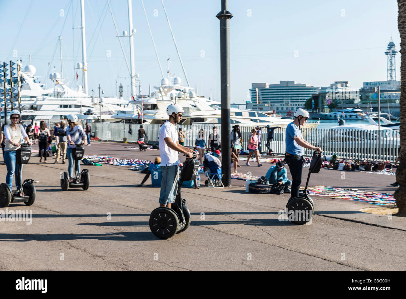 I turisti su un Segway nel lungomare pieno di turisti e con un mercato delle pulci a Barcellona, in Catalogna, Spagna Foto Stock