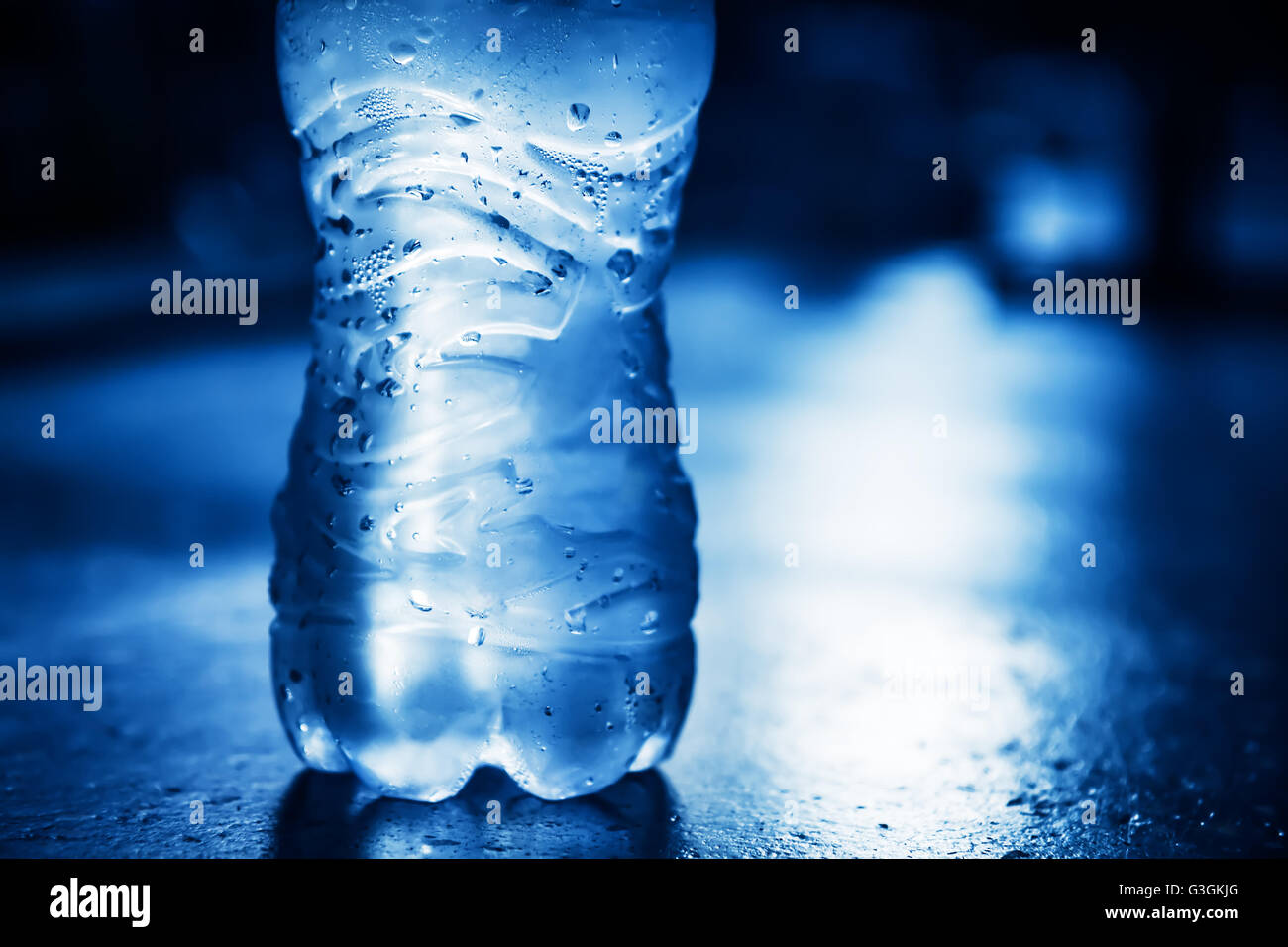 Bottiglia di acqua pura con gocce di condensa e luce posteriore Foto Stock