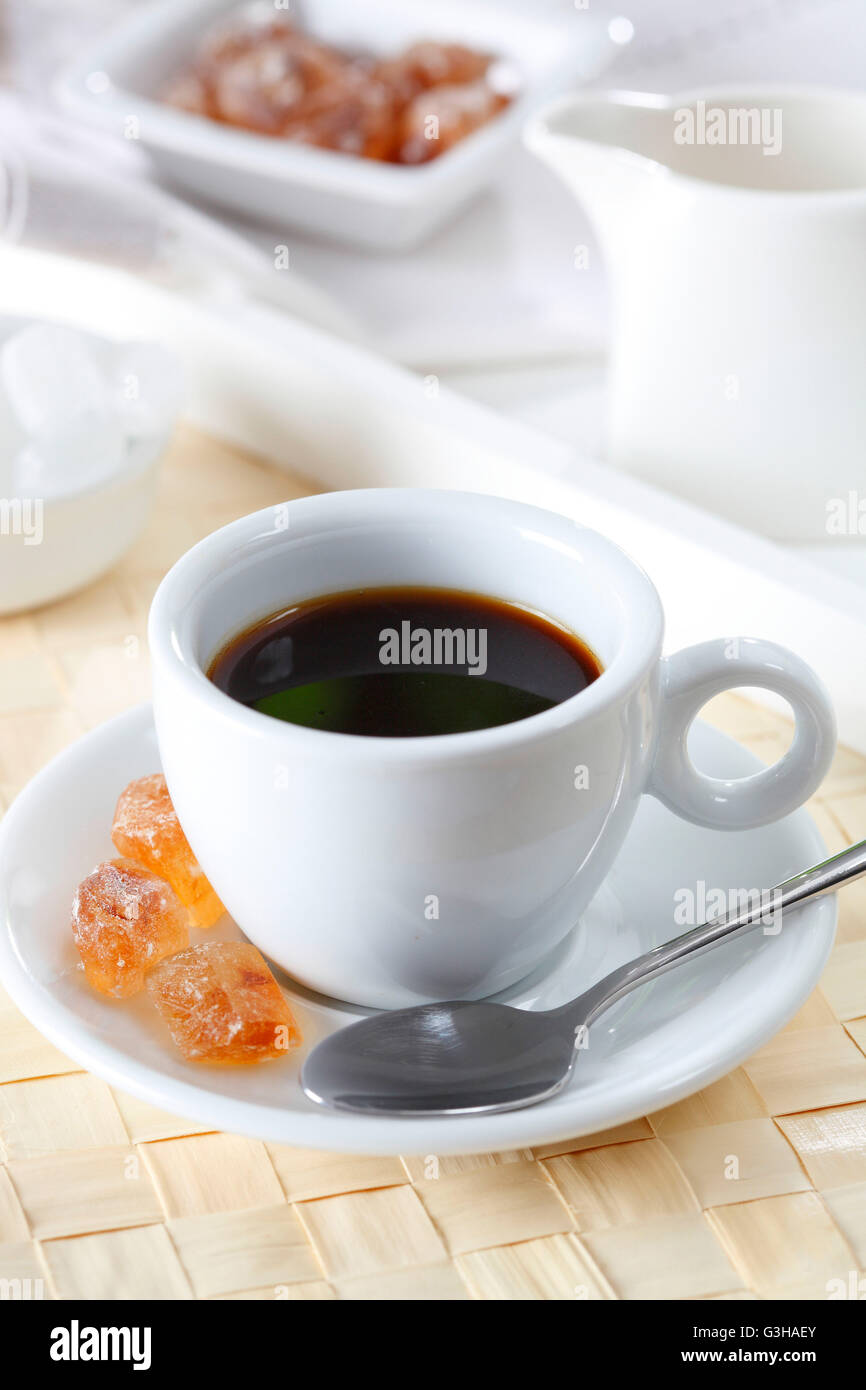 Nero deliziosi caffè espresso e cucchiaio marrone con lo zucchero candito Foto Stock