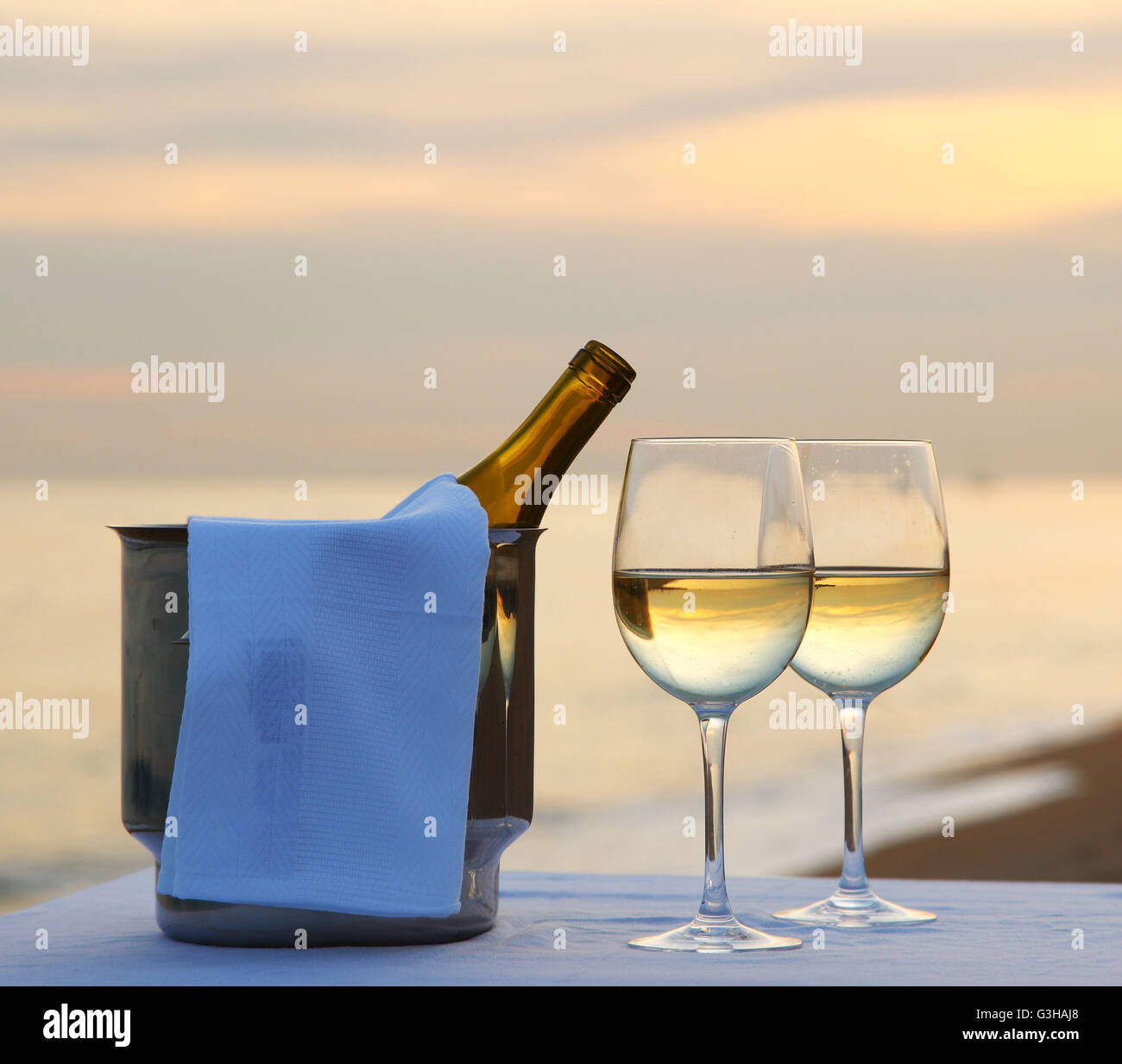 Cena romantica in spiaggia con vino bianco in un refrigeratore Foto Stock