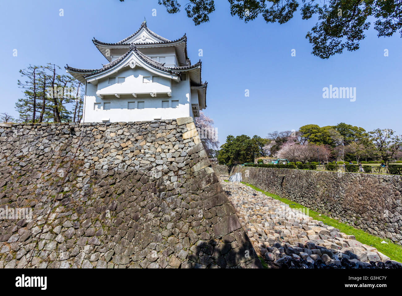 L'angolo sud est torretta, Tatsumi yagura, sulla parte superiore del muro di pietra base con fossato asciutto. Il Castello Nagoya, Giappone. La primavera con cielo blu. Foto Stock