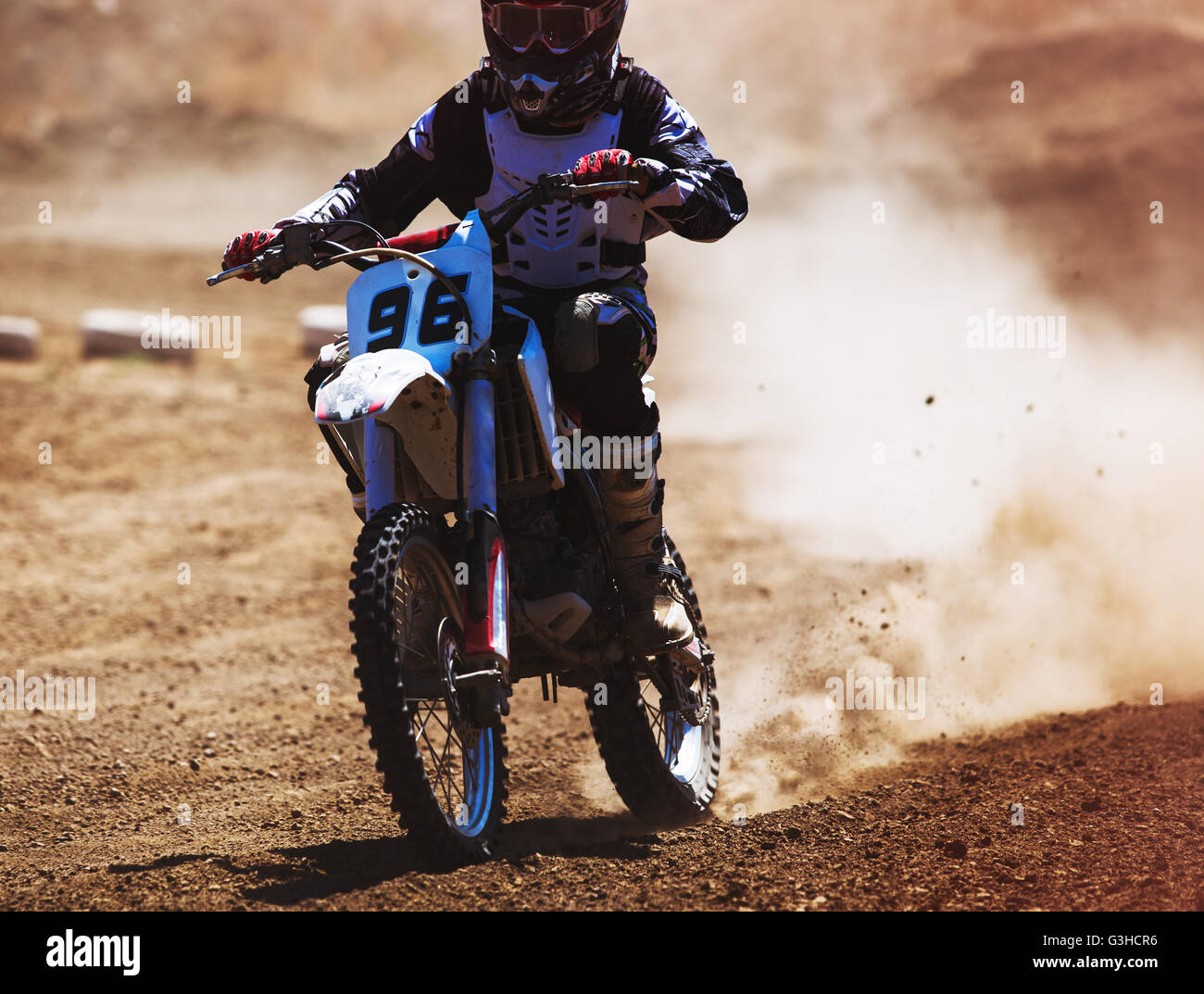 Motocross racer accelerando in polvere via Foto Stock