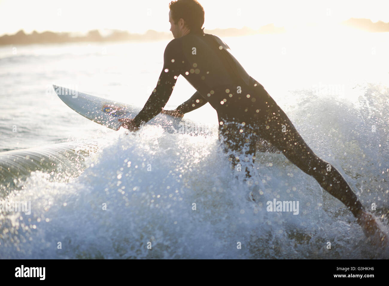 Surfista maschio surf Oceano in onda sulla Spiaggia di Venice, California, Stati Uniti d'America Foto Stock