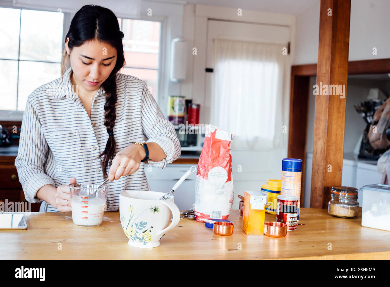 La donna in cucina preparare waffle pastella Foto Stock