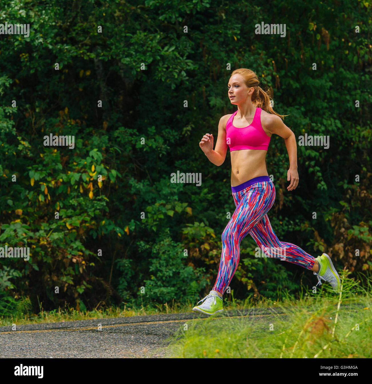 Femmina adolescente runner acceso lungo la strada rurale Foto Stock