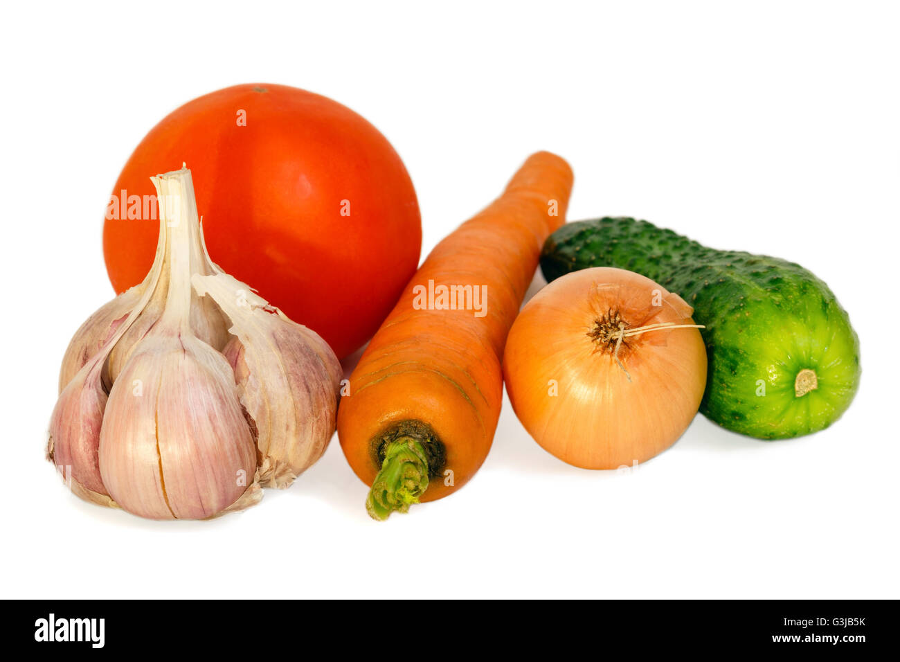 Composizione di verdure (carota, cetrioli, aglio, cipolla, pomodoro) isolato su bianco. Foto Stock