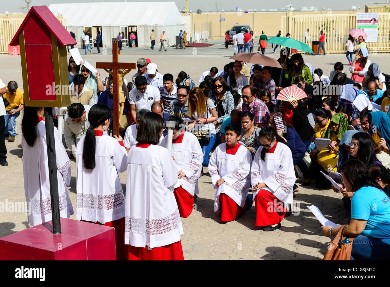 Il Qatar Doha, complesso religioso con chiese, filippino lavoratore migrante di andare a Messa venerdì / KATAR, Doha, Religionskomplex mit Kirchen am Stadtrand, katholische Kirche di Gastarbeiter philippinische in Tagalog Messe am Freitag, Kreuzgang, Hintergrund Zelt fuer security check der polizia Qatar Foto Stock