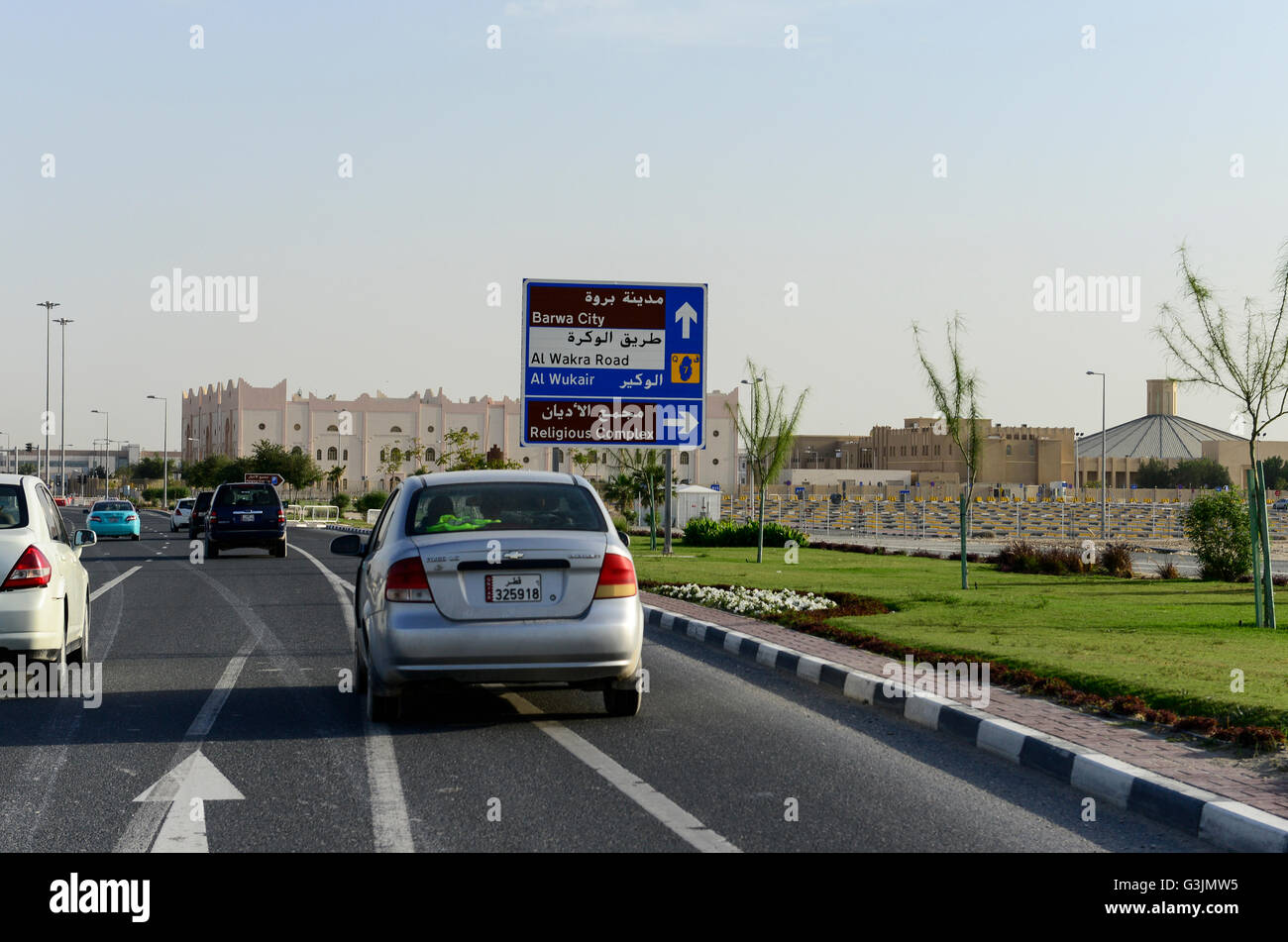 Il Qatar Doha, strada e posto di parcheggio al complesso religioso con le chiese cristiane per i lavoratori migranti, a destra la chiesa cattolica Foto Stock