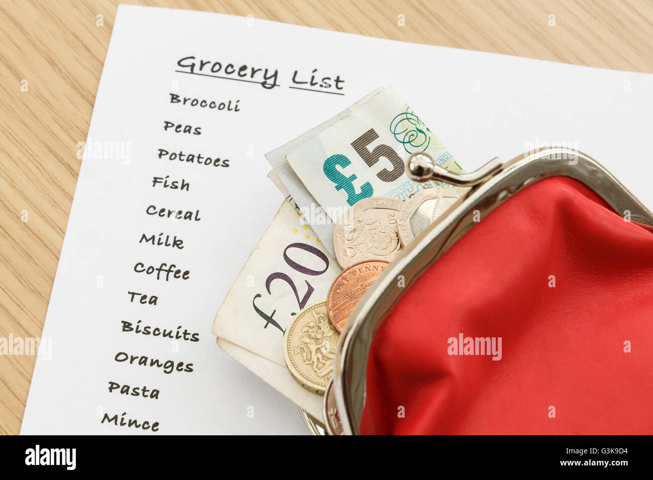 Lista della spesa per i generi alimentari con sterling soldi contanti GBP in una borsa da sopra. Inghilterra, Regno Unito, Gran Bretagna Foto Stock