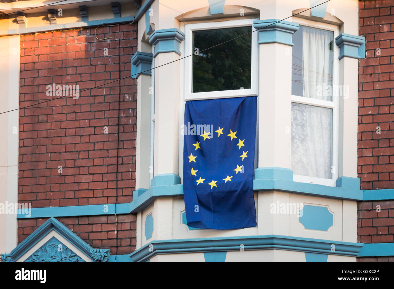 Una bandiera UE pende da una finestra di casa prima del referendum dell'UE. Foto Stock