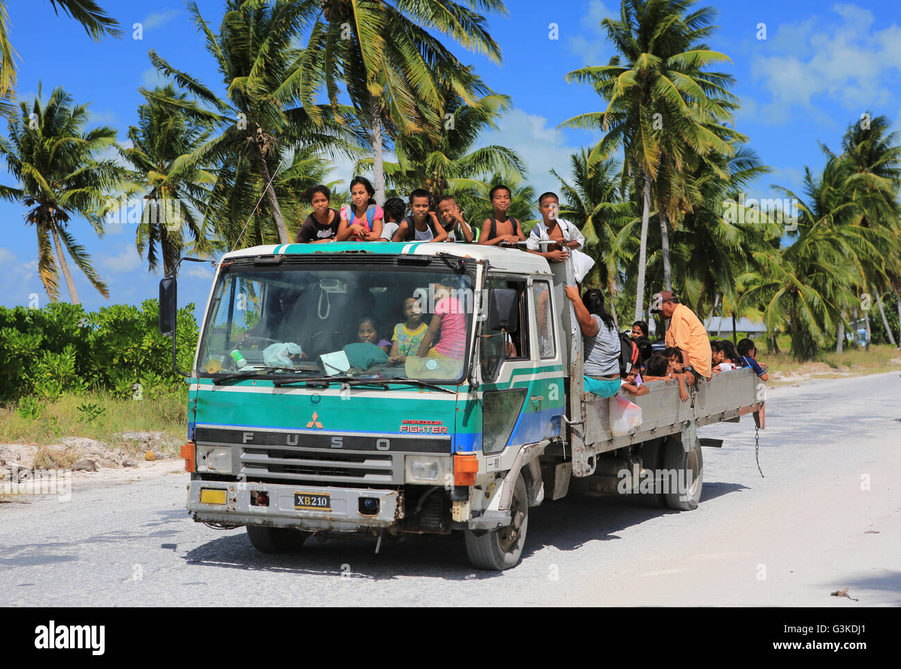 Bambini locali di agganciare una corsa a casa da scuola, Isola di Natale, Kiribati Foto Stock