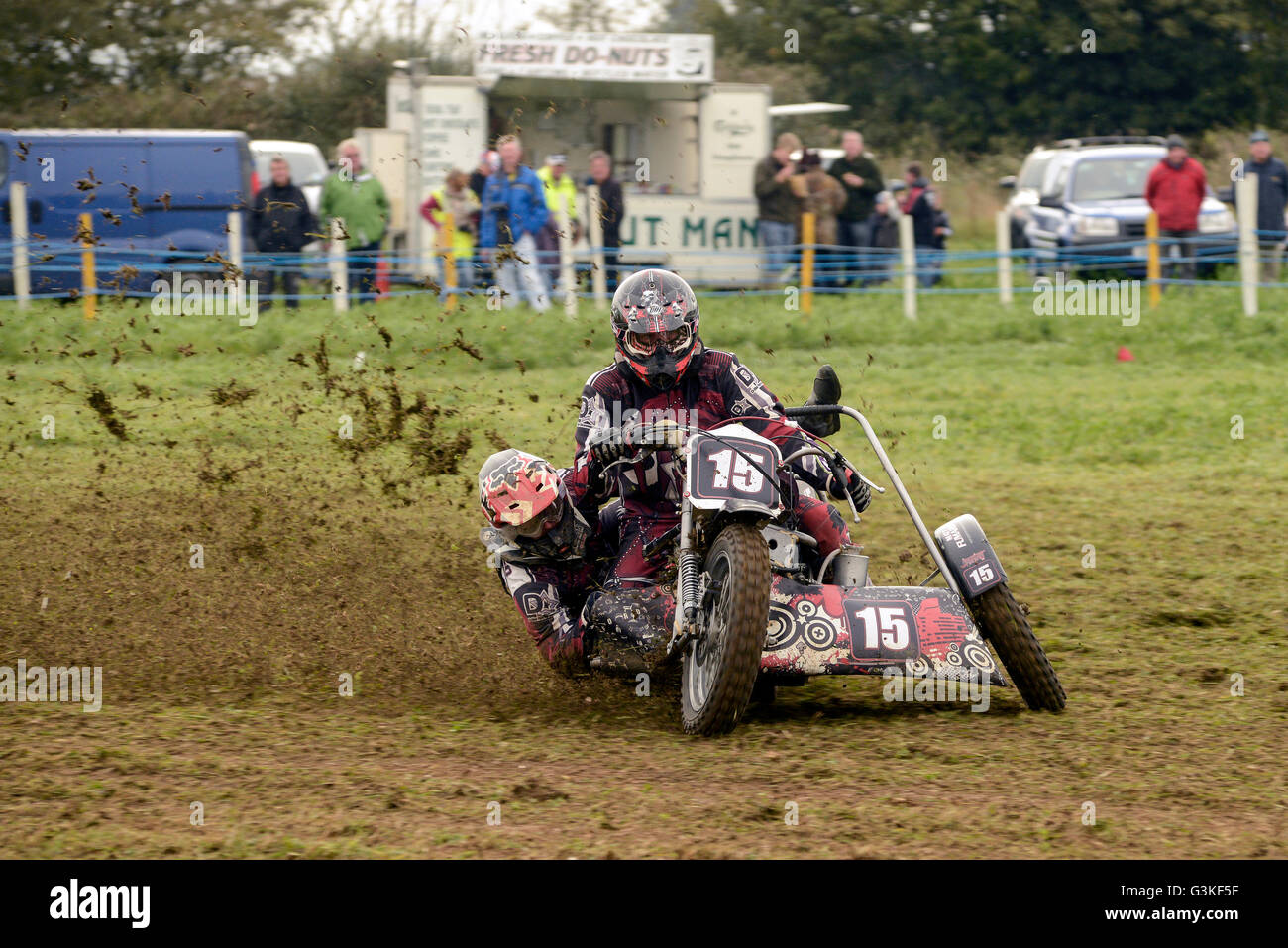 Moto sidecar team una curva a erba via evento racing con gli spettatori a guardare Foto Stock