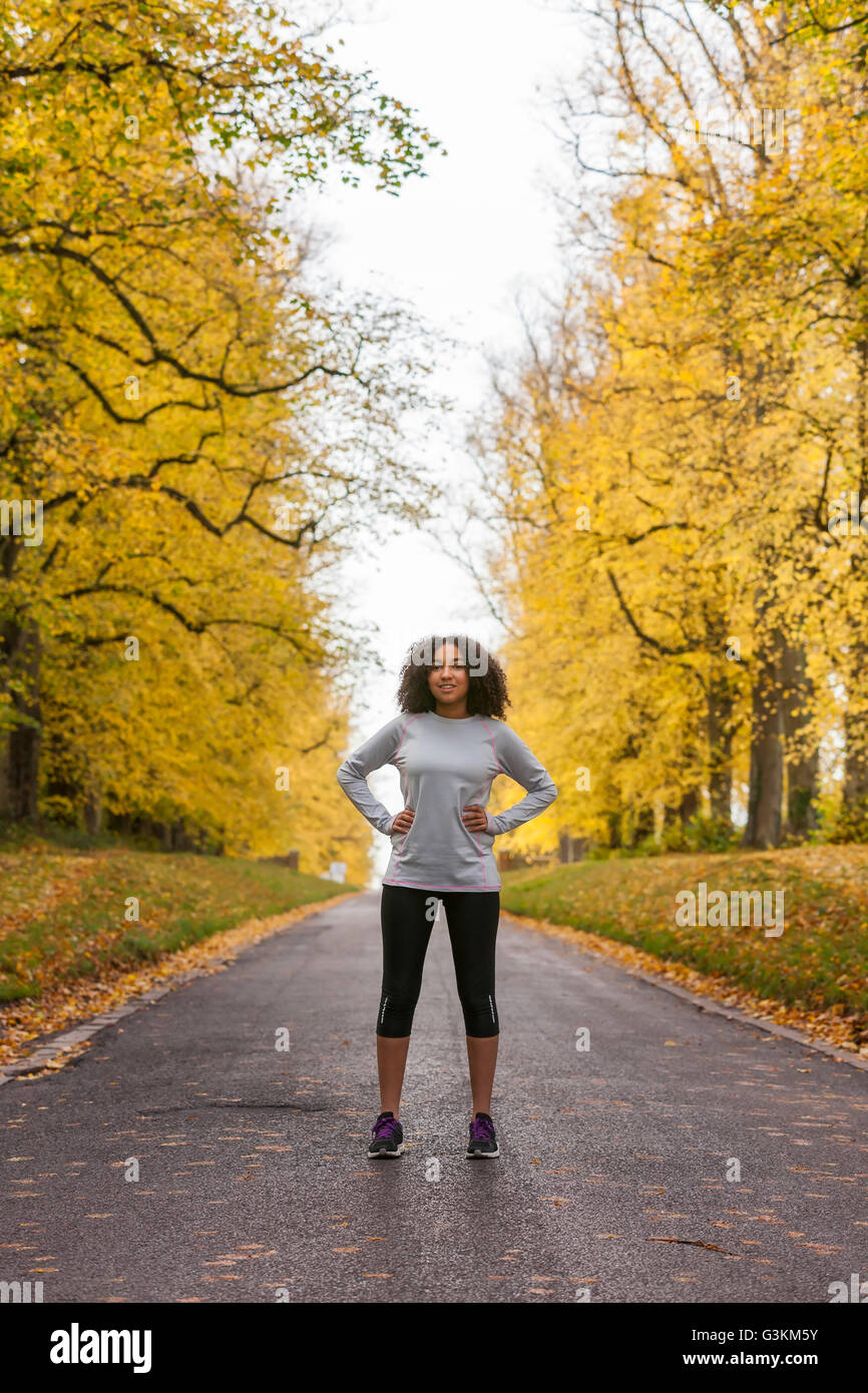 Bellissima gara di misto americano africano donna giovane ragazza adolescente in esecuzione fitness jogging in autunno cadono alberi Foto Stock