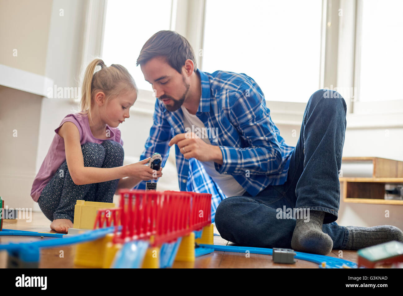 Padre e figlia gioca con toy train set Foto Stock