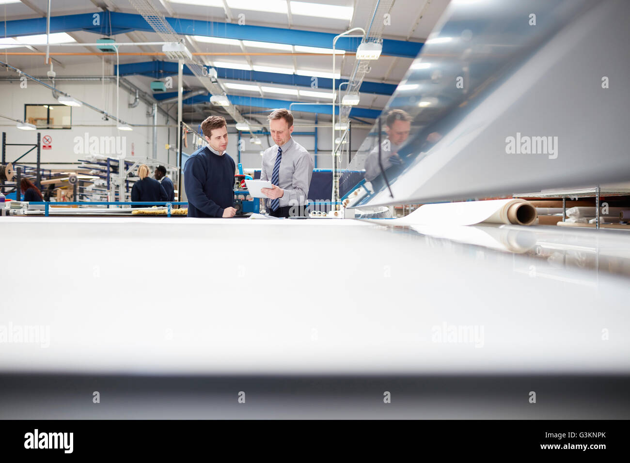 Manager e operaio di fabbrica a discutere di lavoro in tenda a rullo factory Foto Stock