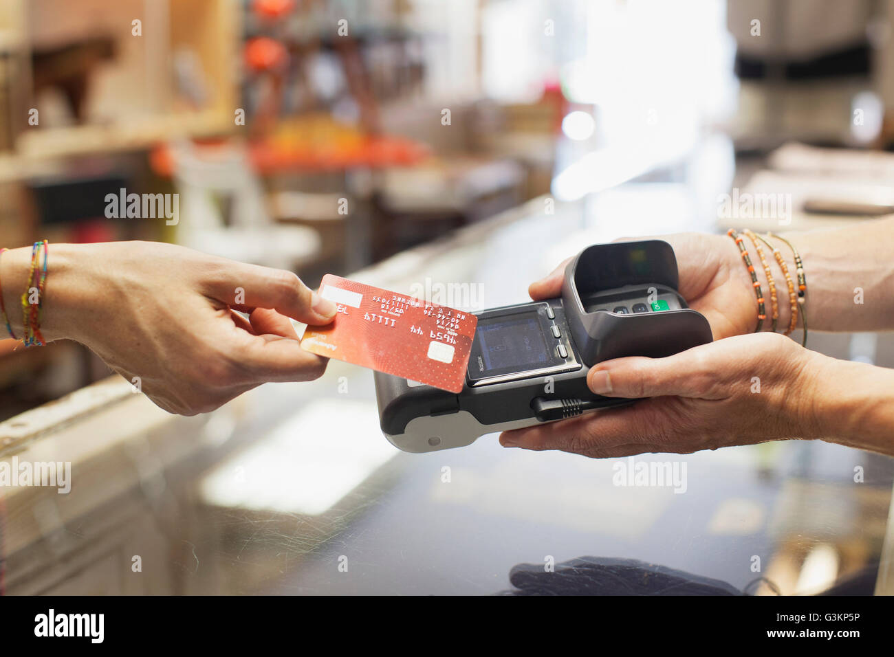 Vista ritagliata della womens mano tramite carta di credito per effettuare il pagamento senza contatto su chip e pin macchina Foto Stock