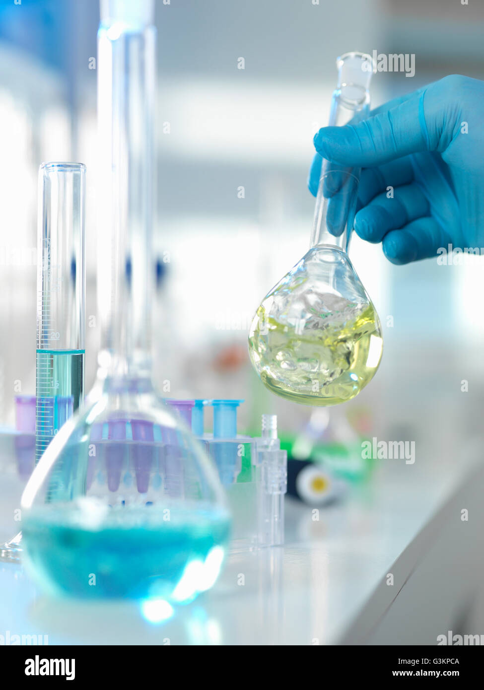 Scienziato preparando una formula chimica in una beuta conica durante un esperimento in laboratorio Foto Stock