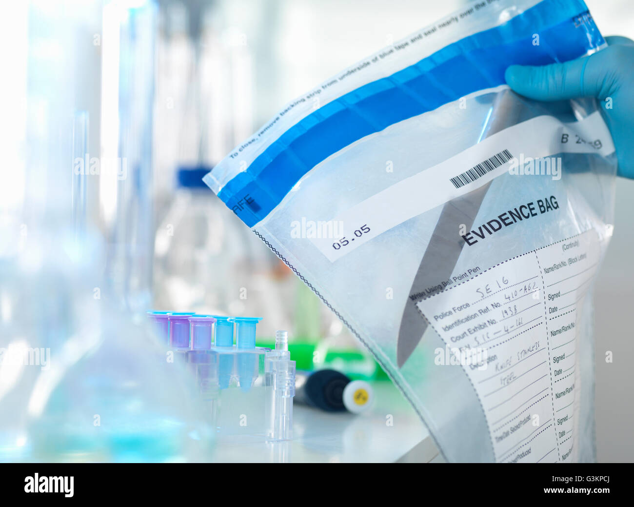 Lo scienziato forense preparare un coltello preso da una scena del crimine per analisi del DNA Foto Stock