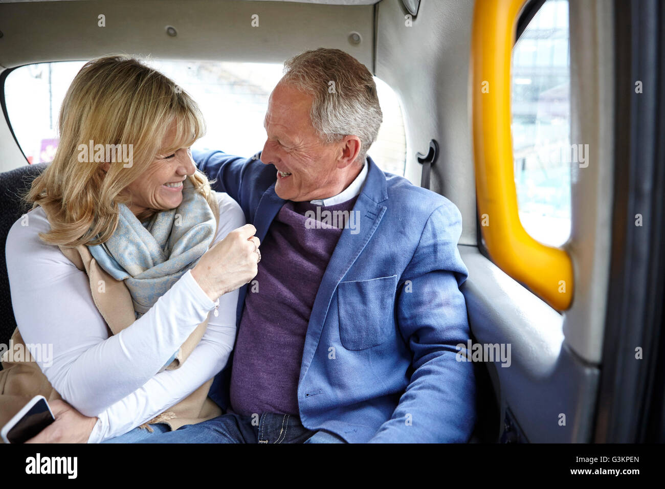 Mature Dating giovane lungo il tragitto in taxi nero backseat Foto Stock