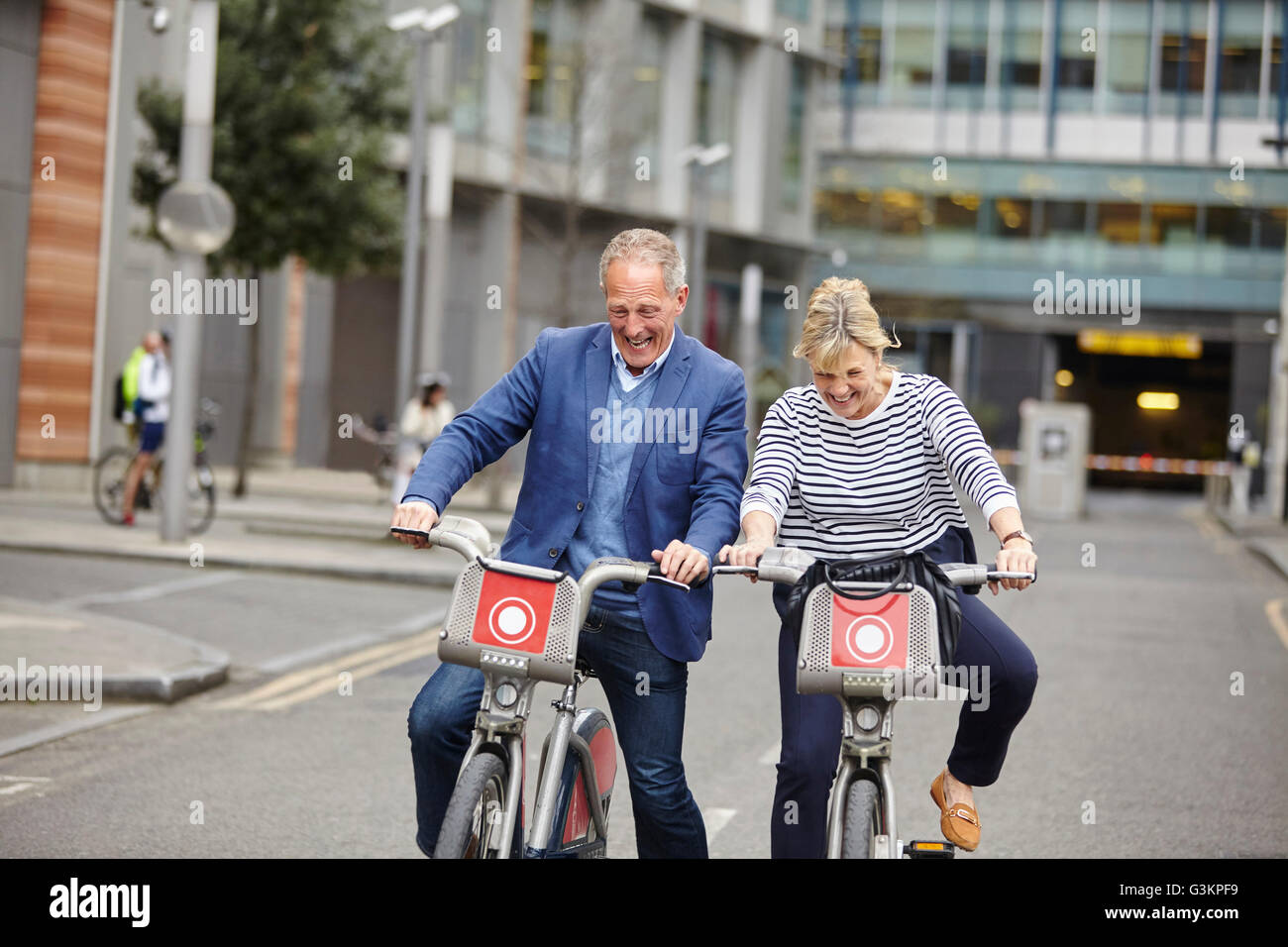 Mature Dating giovane rideva mentre il ciclismo su noleggio biciclette, London, Regno Unito Foto Stock