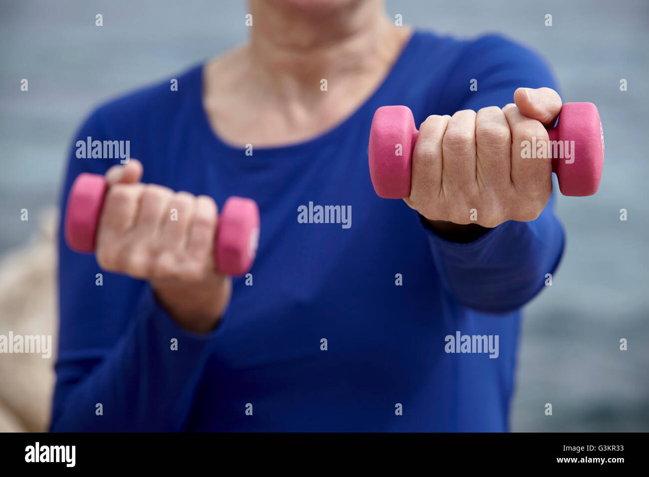 Donna matura all'aperto, allenamento con i pesi a mano Foto Stock
