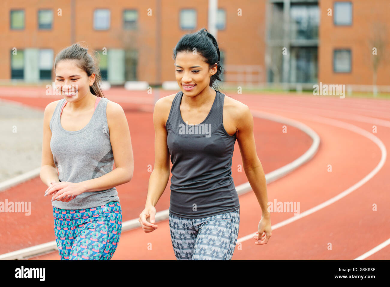 Due giovani donne a piedi lungo via di corsa Foto Stock