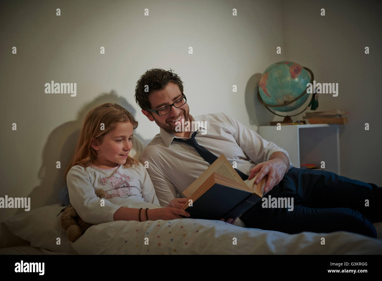 Imprenditore storybook di lettura alla figlia prima di andare a dormire Foto Stock