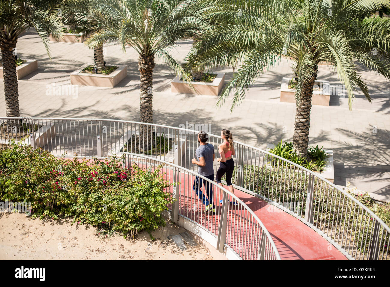 Elevato angolo di vista In esecuzione giovane correndo giù passerella, Dubai, Emirati Arabi Uniti Foto Stock
